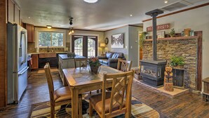 A spacious kitchen with a dining area, a fireplace, and a stone accent wall. - Home w/ Jacuzzi: 10 Mi to NAU & Flagstaff! (Flagstaff)