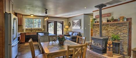 A spacious kitchen with a dining area, a fireplace, and a stone accent wall.