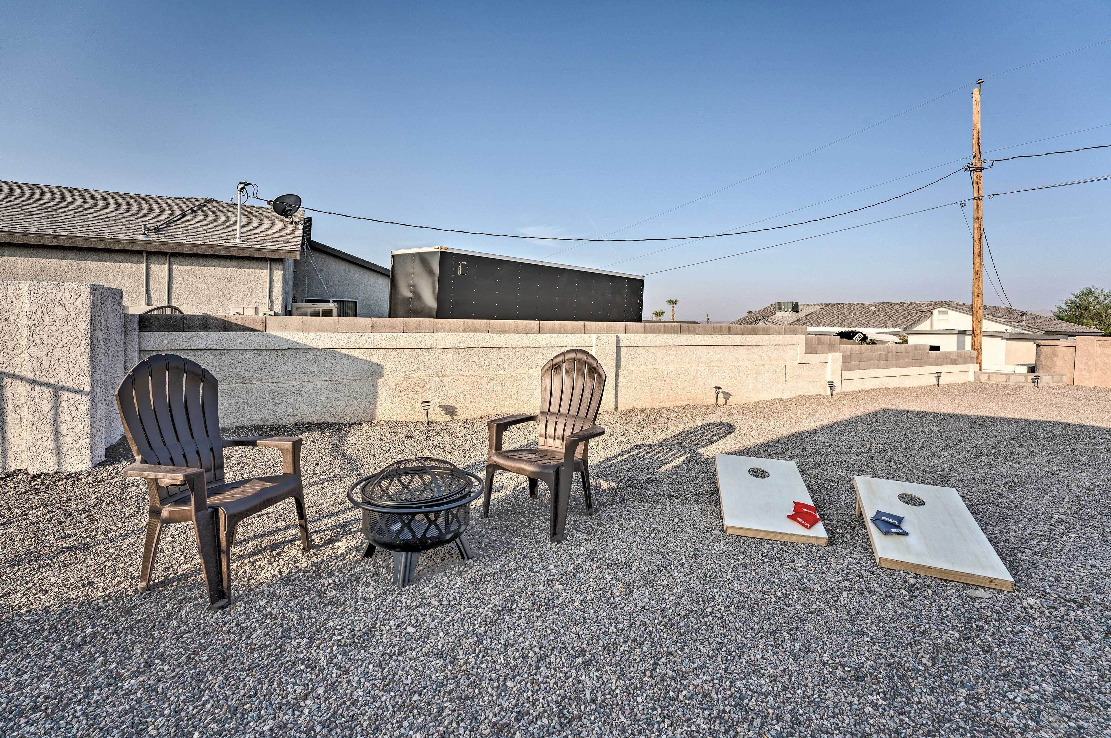 Un espace extérieur aménagé avec deux fauteuils Adirondack et un foyer.