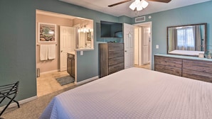 A bedroom with a large bed, a ceiling fan, a dresser, a mirror, and a bathroom visible through an open door. - 3 Mi to Water: Lake Havasu Gem w/ Fire Pit & Grill (Lake Havasu City)