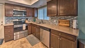A modern kitchen with dark wood cabinets, stainless steel appliances, and a mosaic tile backsplash. - 3 Mi to Water: Lake Havasu Gem w/ Fire Pit & Grill (Lake Havasu City)
