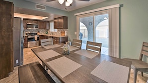 A modern kitchen with dark wood cabinets, stainless steel appliances, and a dining area with a large table and chairs. - 3 Mi to Water: Lake Havasu Gem w/ Fire Pit & Grill (Lake Havasu City)