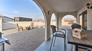 An outdoor patio area with a concrete floor, two wooden tables, and four chairs. - 3 Mi to Water: Lake Havasu Gem w/ Fire Pit & Grill (Lake Havasu City)