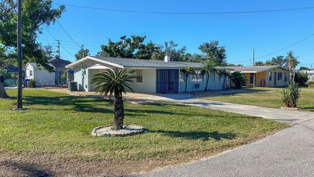 A single-story house with a front yard, a palm tree, and a clear blue sky. - 1 Mi to Beach: Nokomis Home w/ Private Pool (Nokomis)