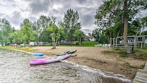 Ein Strand mit Kajaks und einer Holzterrasse.