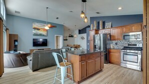 Una cucina moderna con mobili in legno, elettrodomestici in acciaio inossidabile e una grande isola.