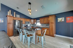 A modern kitchen with wooden cabinets, stainless steel appliances, and a central island with bar stools. - Bright Getaway w/ Ski Lake, 11 Miles to Dtwn Tampa (Brandon)