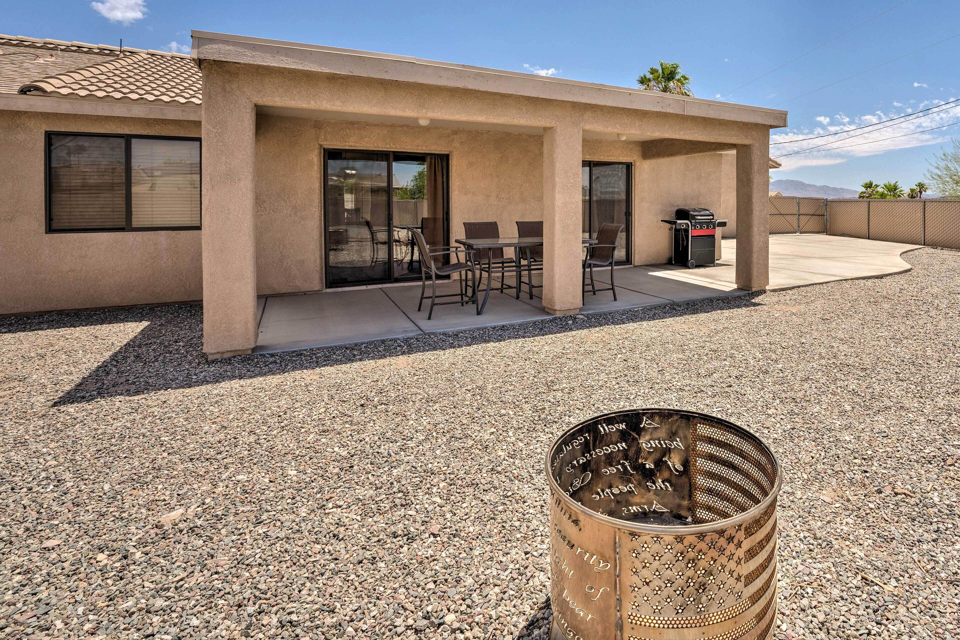 Une maison avec un patio, un barbecue et un tonneau en métal décoratif.