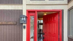 A red door with a glass panel, a wooden sign above it, and a black lantern to the left. - 'the Overlook' in Massanuttens All Season Resort (McGaheysville)