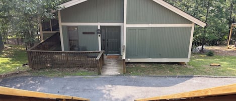 A small, single-story building with a sloped roof, a front door, and a small porch area.