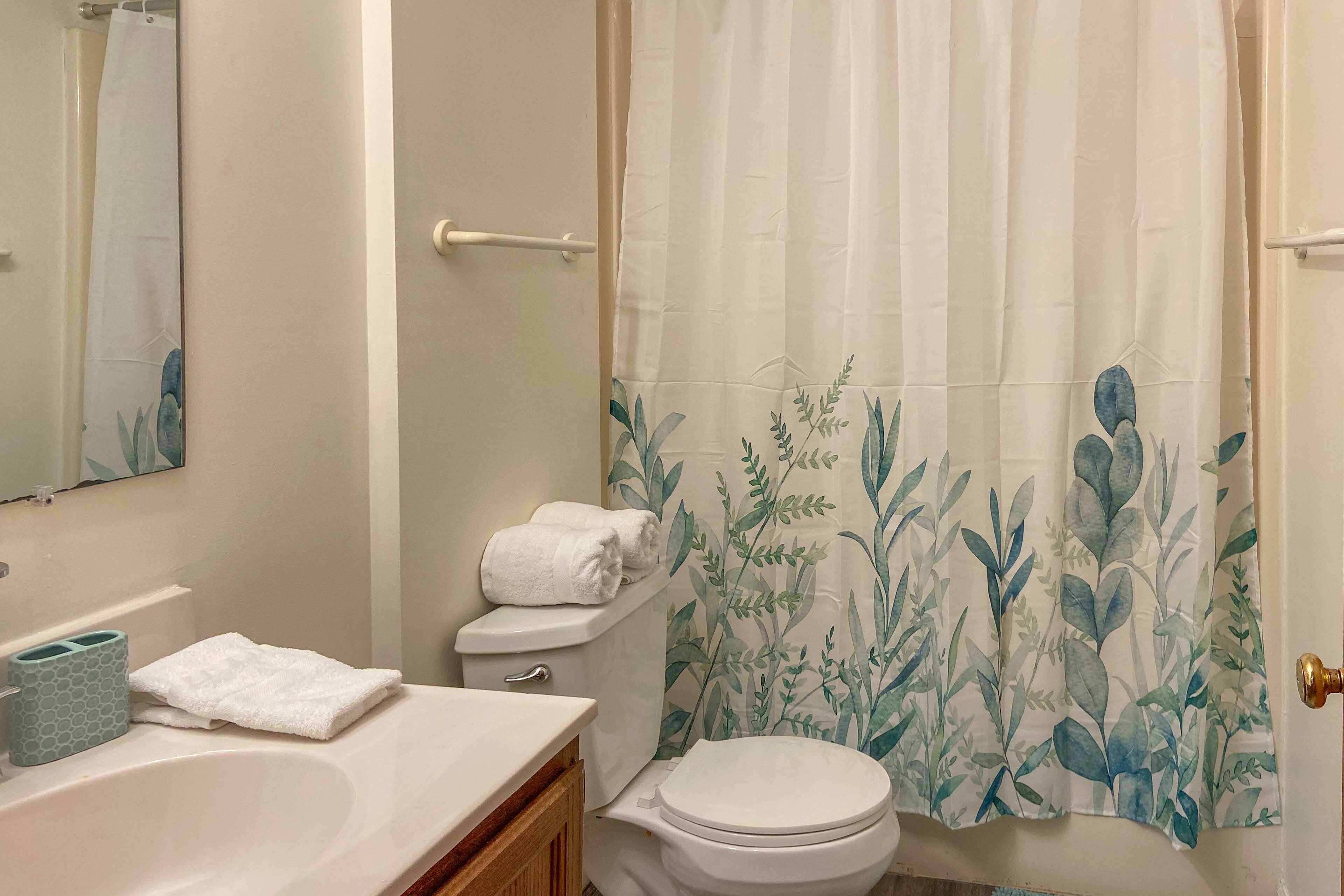 A bathroom with a bathtub, toilet, and sink.