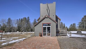 A building with a brick entrance and a metal staircase leading to a door. - Renovated Historic Church Along Namekagon River! (Hayward)