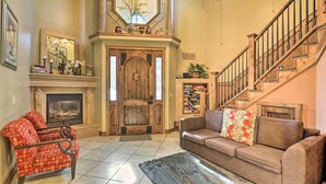 A spacious living room with a fireplace, a staircase, and a cozy seating area.