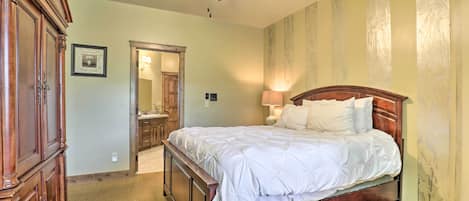 Un dormitorio con una cama de madera, ventilador de techo, mesita de noche y armario.