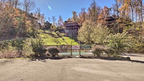 Un espace clos, délimité par une barrière et sur lequel on peut lire une pancarte indiquant « PISCINE FERMÉE », entouré d’arbres et de bâtiments, ce qui suggère qu’il s’agit d’un complexe hôtelier ou d’un chalet.