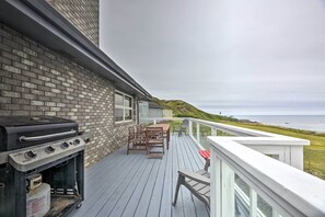 A deck with a grill, outdoor furniture, and a view of the ocean. - Luxurious Newport Estate w/ Spa & Lighthouse Views (Newport)
