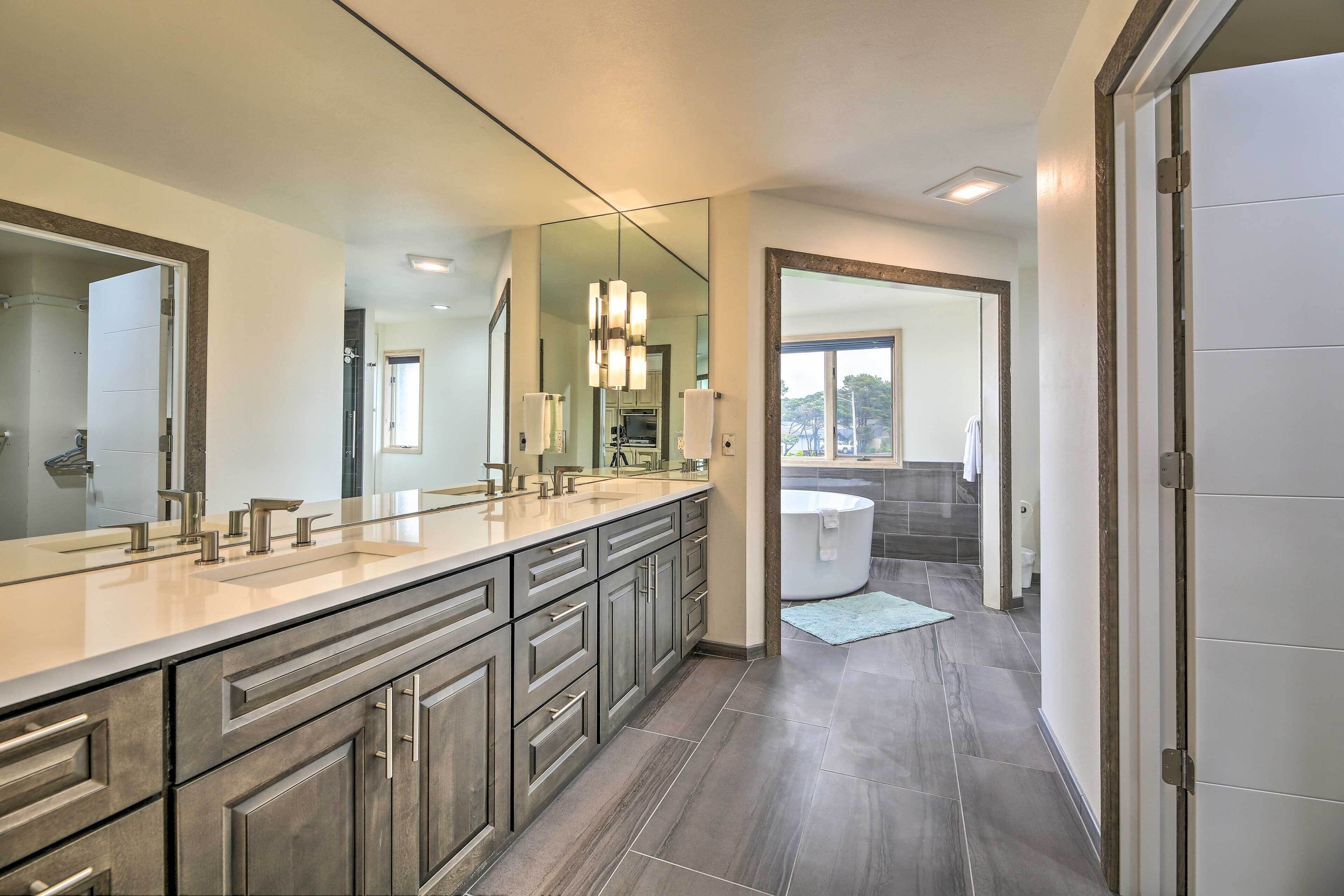 A modern bathroom with a large vanity, a walk-in shower, and a bathtub.