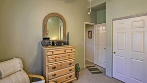 A hallway with a wooden dresser, a mirror, and a ceiling fan. There are white doors and a carpeted floor. - Charming Anthem Home w/ Fire Pit, 1 Mi to Park! (Phoenix)