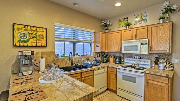 A kitchen with wooden cabinets, a microwave, a stove, and a coffee machine. - Charming Anthem Home w/ Fire Pit, 1 Mi to Park! (Phoenix)
