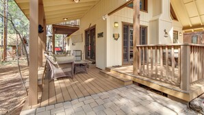 A wooden deck with outdoor furniture, a covered porch, and a stone wall. - 9 Mi to Rainbow Lake: Woodsy Pinetop Cabin w/ Deck (Pinetop)
