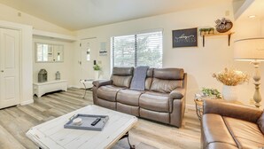 A living room with a brown leather sofa, a white coffee table, and a ceiling fan. - Hike, Sled & Snowshoe! Family Retreat in Payson (Payson)