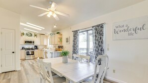 A bright kitchen with white cabinets, a dining table with white chairs, and a ceiling fan. - Hike, Sled & Snowshoe! Family Retreat in Payson (Payson)