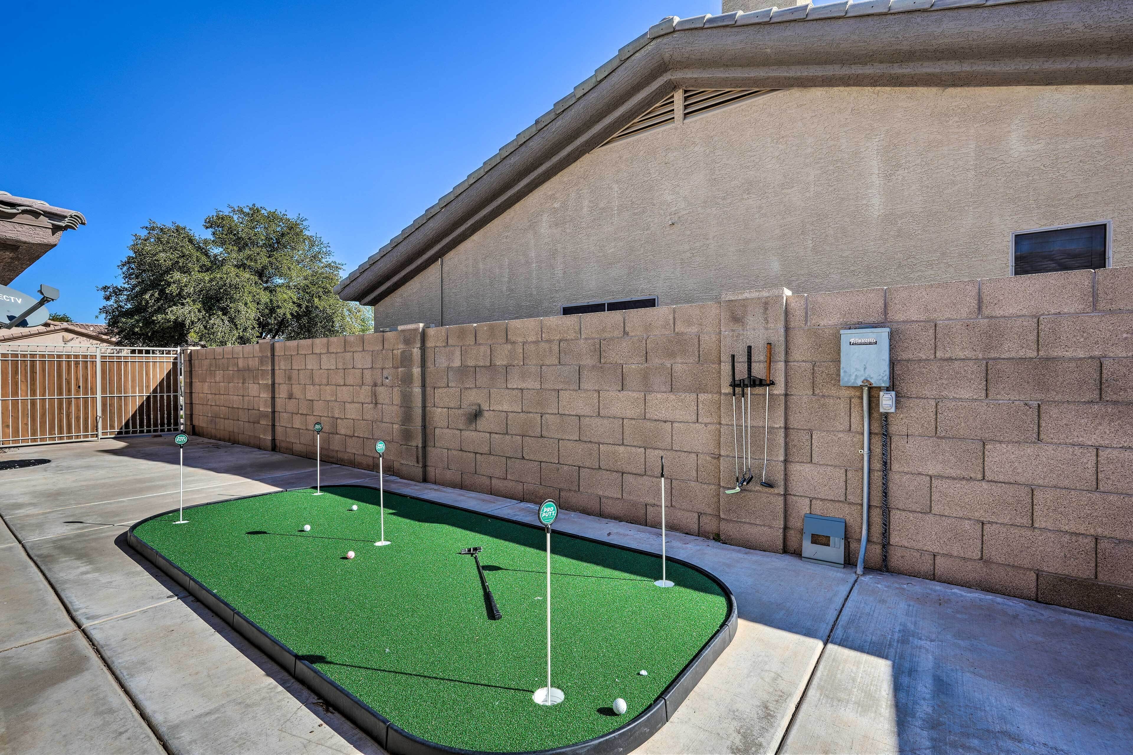 A miniature golf course with a brick wall and a clear sky.