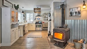 A kitchen with white cabinetry, a central island, a stove, and a hanging light fixture. - Modern Farmhouse w/ Movie Room - 6 Mi to Lake! (Coeur d'Alene)