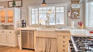 A kitchen with a large window, white cabinetry, a stainless steel refrigerator, and a gas stove. - Modern Farmhouse w/ Movie Room - 6 Mi to Lake! (Coeur d'Alene)