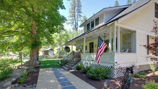A house with a porch, a flag, and a garden path. - Modern Farmhouse w/ Movie Room - 6 Mi to Lake! (Coeur d'Alene)