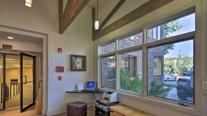 A hotel lobby with a reception desk, a computer, a printer, and a large window offering a view of the outside. - Ski-in/ski-out Studio in Aspen Snowmass Ski Resort (Snowmass Village)