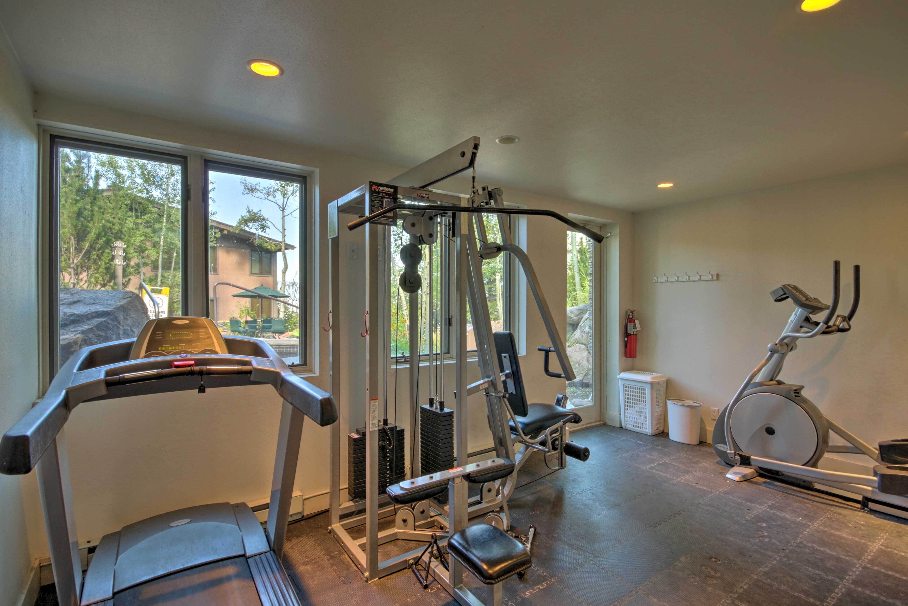 A gym with a treadmill, weight machine, and stationary bike.