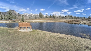 A bench by a lake with mountains in the background.