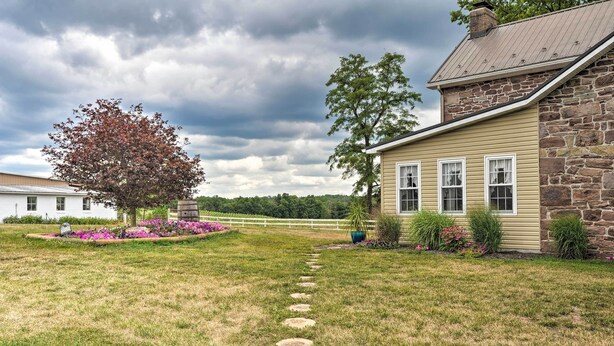 Une maison en pierre, avec des fondations en pierre et un revêtement extérieur jaune.