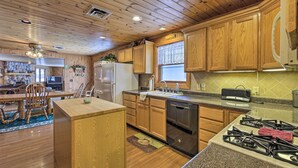 A kitchen with wooden cabinets, a refrigerator, a dishwasher, and a gas stove. - Lakefront Escape w/ Fishing Pier & Snowmobiling! (Park Falls)