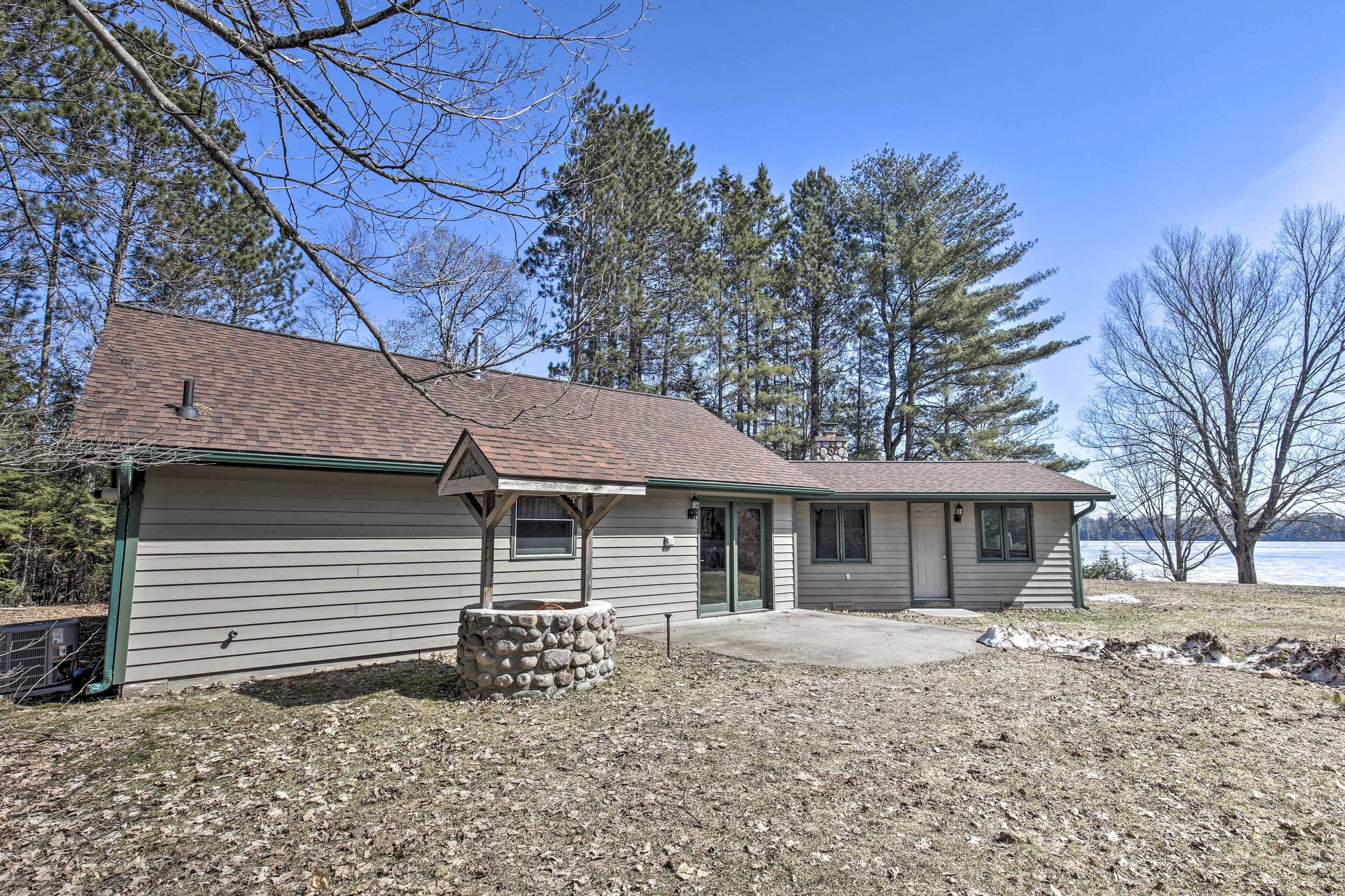 A single-story house with a sloped roof, a stone foundation, and a front porch.