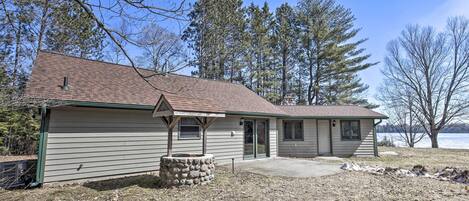 A single-story house with a sloped roof, a stone foundation, and a front porch.