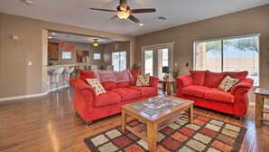 A spacious living room with a red sofa set, a wooden coffee table, and a patterned rug. - Maricopa Home w/ Outdoor Seating, 2 Mi to Golf! (Maricopa)