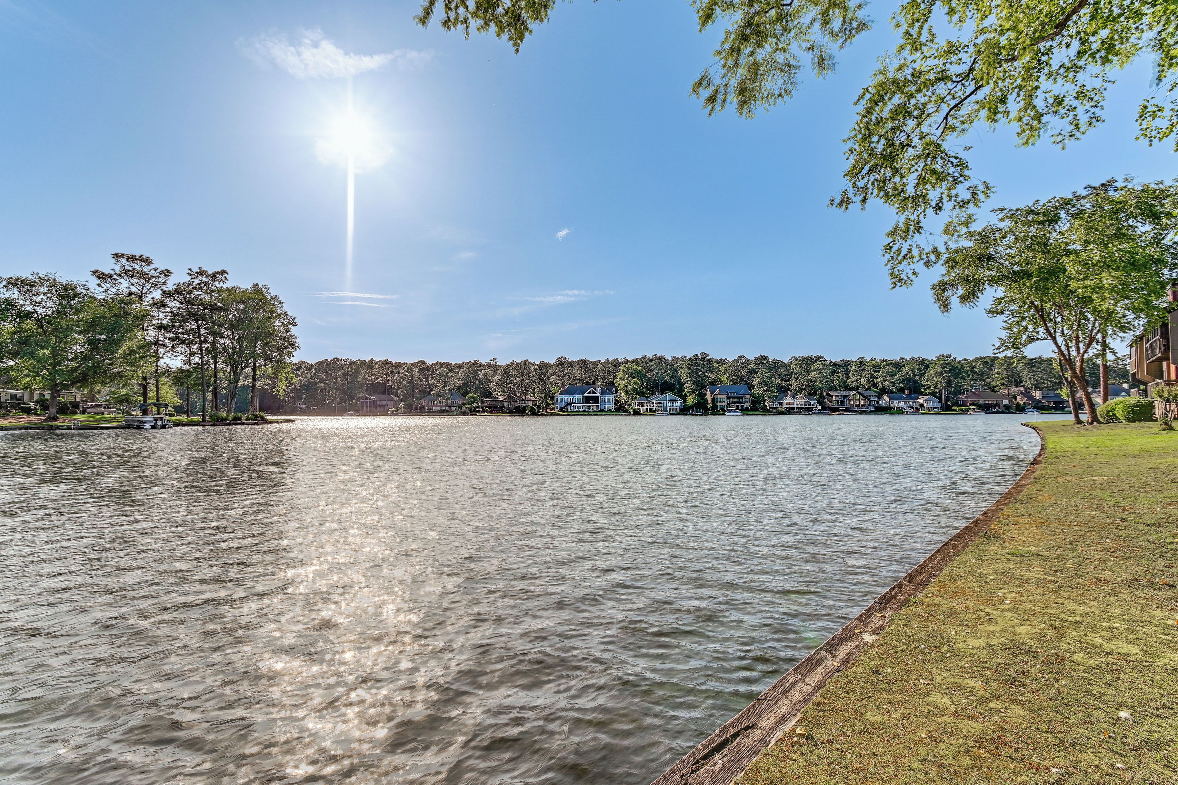 A waterfront property with a grassy area and a view of the lake.