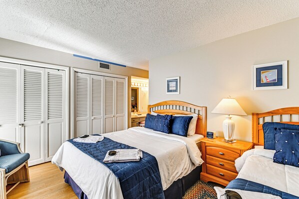 A hotel room with a bed, a nightstand, a lamp, a chair, and a wardrobe. - Lakeview Condo w/ Resort Pool: 2 Miles to Golf! (Pinehurst)