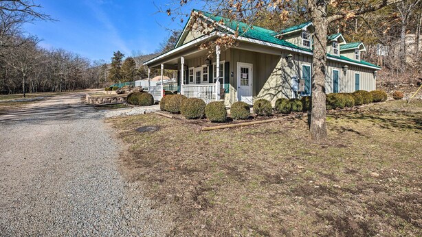 A two-story house with a porch, surrounded by a gravel driveway and trimmed bushes. - Blue Eye Condo on Morningside Church Campus! (Blue Eye)