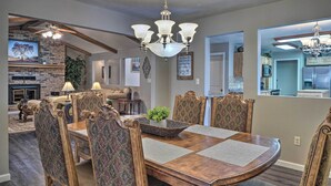 A dining area with a wooden table, upholstered chairs, and a chandelier. - Waterfront Hollister Retreat w/ Dock & Game Room! (Hollister)