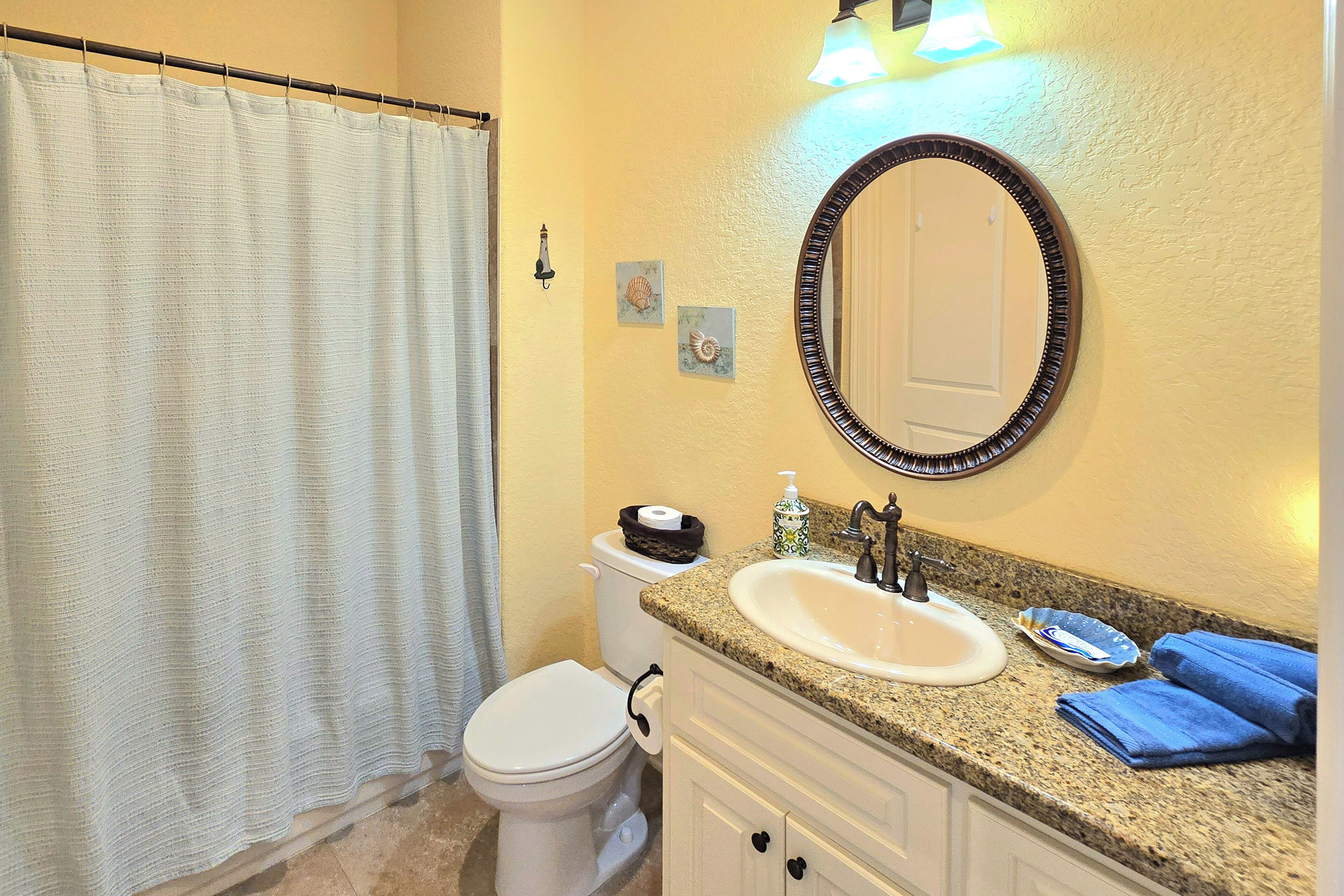A bathroom with a toilet, sink, and mirror.