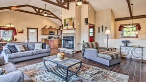 A spacious living room with a fireplace, a sofa, a coffee table, and a dining area.