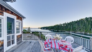 Eine Terrasse mit Essplatz, mit Blick auf einen See und einen Wald.