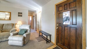 A living room with a sofa, a chair, a lamp, and a wooden door with a window. - 'cedar House' - Family-friendly Cortez w/ Yard! (Cortez)