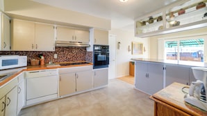 A kitchen with white cabinets, a microwave, a stove, and a coffee maker. - 'cedar House' - Family-friendly Cortez w/ Yard! (Cortez)