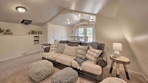 Ein gemütliches Wohnzimmer mit einer Couch, Hocker und einer Lampe.