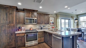 Una cocina moderna con armarios de madera, electrodomésticos de acero inoxidable y una isla grande.