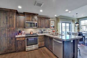 Una cocina moderna con armarios de madera, electrodomésticos de acero inoxidable y una isla grande.